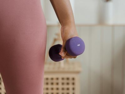 Close-up of a hand gripping a light dumbbell with determination.